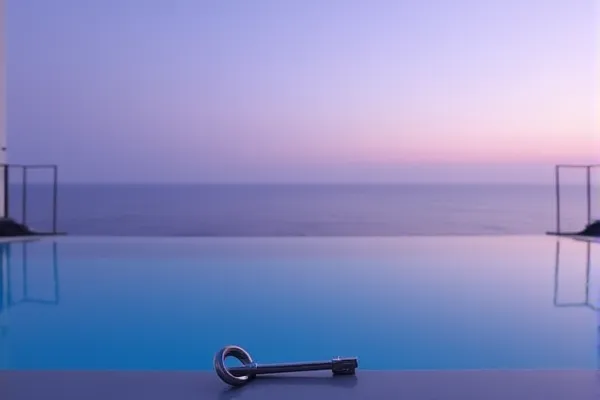 A clear reflection of a modern structure appears on a transparent surface, suggesting a state of perfect liquid equilibrium and clarity.